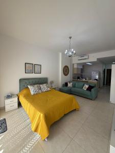 una camera con letto giallo e divano di Rental unit in RAHA village compound, special view ad Aqaba Altre 28 foto