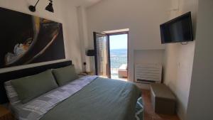 a bedroom with a bed and a flat screen tv at La Stalla e il Fienile suites viste mozzafiato in Norma