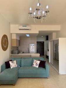 un soggiorno con un divano blu e una cucina di Rental unit in RAHA village compound, special view ad Aqaba