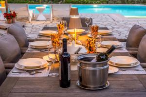 a table set for a meal with wine bottles at Kronos Estate Lefkada - 5 star luxury in Mikros Gialos +63 photos