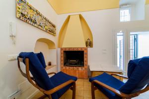 a living room with two blue chairs and a fireplace at Casa di Zia Rosaria SEA VIEW in Vietri sul Mare