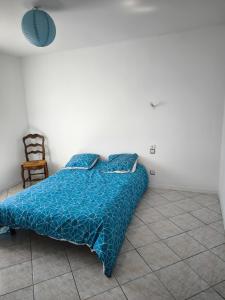 1 dormitorio con 1 cama con edredón azul y silla en Villa Cailar, en Le Cailar
