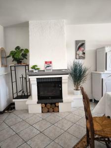 Una sala de estar con chimenea y una silla. en Villa Cailar, en Le Cailar
