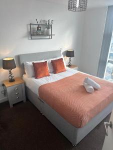 City View One Bedroom Apartment في ليفربول: غرفة نوم مع سرير كبير مع وسائد برتقالية