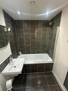 City View One Bedroom Apartment في ليفربول: حمام مع حوض استحمام أبيض ومغسلة +13 صورة