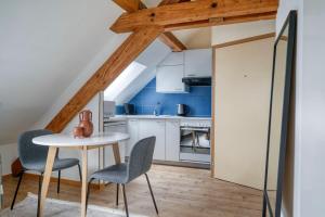 a kitchen with a table and chairs in a room at Eagle Suite Charmante Dachgeschosswohnung mit Design & Ausblick in Zurich