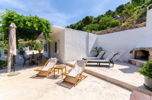 een patio met stoelen, een tafel en een open haard bij House Herta in Gdinj