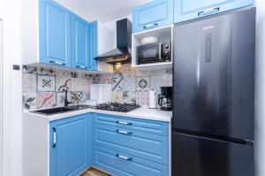een keuken met blauwe kasten en een roestvrijstalen koelkast bij House Herta in Gdinj