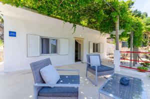 a patio with two chairs and a table at House Herta in Gdinj +25 photos
