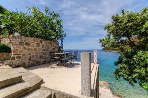 a table and chairs on the beach near the water at House Herta in Gdinj