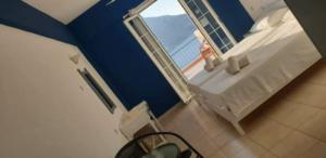 a bedroom with a bed and a window with a balcony at Louis Studios Masouri in Kalymnos