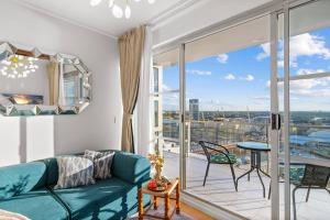 Una sala de estar con un sofá y un balcón. en Urban Oasis Escape - Views丨Comfort丨Elegance, en Sídney