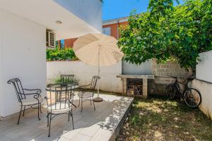a patio with a table and chairs and an umbrella at House Korbar in Vir
