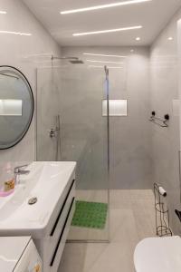 a white bathroom with a shower and a sink at Spacious 2 bedroom apartment in Durres Beach in Durrës