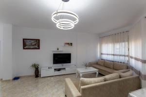 a living room with a couch and a tv at Spacious 2 bedroom apartment in Durres Beach in Durrës