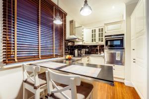 une cuisine avec une table et des chaises et une fenêtre dans l'établissement Sunny apartment by the sea with garage, à Sopot