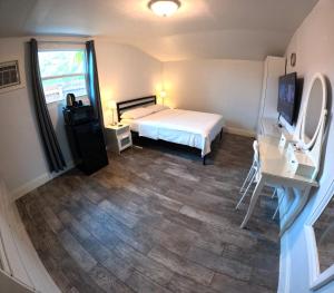 una camera da letto con un letto, una scrivania e una televisione di Nancy Vacation Homes a Hollywood