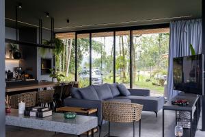 a living room with a blue couch and a table at Cabana Panorama - Parque Floresta Alta in Rodeio