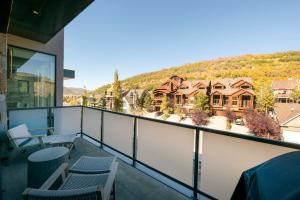 a balcony with chairs and a view of a house at Luxury Townhome with Spectacular Views. Private Hot Tub & Walking Distance to Main Street - in Park City