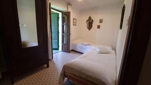 a bedroom with two beds and a mirror and a window at Casa Laura in Madonna della Scala