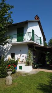 a white building with a balcony and some flowers at Casa Laura in Madonna della Scala