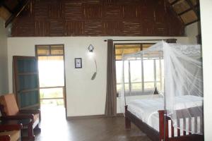 a bedroom with a bed with a canopy at Bar Lyec Safari Lodge in Pakwach East