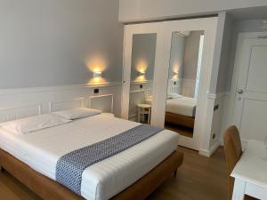 坎帕尼亚朱利亚诺Hotel Barbarella Swimming的带一张大床和一面镜子的卧室