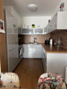 a kitchen with white cabinets and a sink at Apartment with Balcony and Parking, Danube & Green View in Bratislava +4 photos
