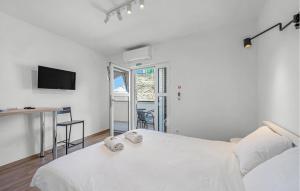 a white bedroom with a bed and a table at 1 Bedroom Beautiful Apartment In Vodice in Vodice