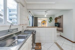ボンバスにあるApto 2Q c varanda a 220m da praia de Bombas FDL103のシンクと窓のあるキッチン