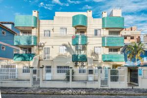 ボンバスにあるApto 2Q c varanda a 220m da praia de Bombas FDL103の側面にバルコニーがある建物