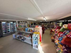 a store aisle of a grocery store with shelves of food at The Green - Summer Breeze in Crantock