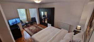 a living room with a white couch and a television at Apartament 2 camere central Otopeni in Otopeni