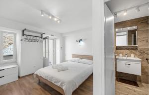 a white bedroom with a bed and a sink at 1 Bedroom Nice Apartment In Vodice in Vodice