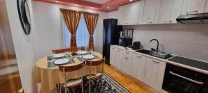 a kitchen with a table with chairs and a sink at Apartament 2 camere central Otopeni in Otopeni