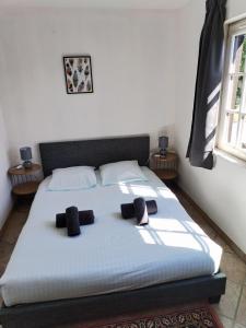 a bedroom with a bed with two pillows on it at Le Presbytère - La Trêverie in Le Torquesne