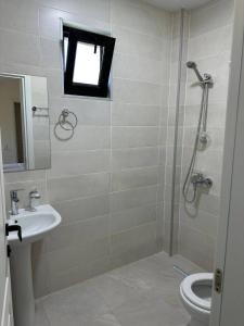 a bathroom with a shower and a toilet and a sink at Hotel Heart in Gonio +18 photos