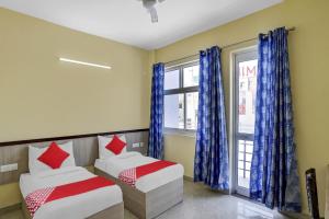 a bedroom with two beds and a window at Hotel O MT Stays 1 in Murādnagar