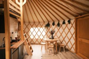 a room with a table and chairs in a yurt at Oaza Wśród Pól in Rożubowice
