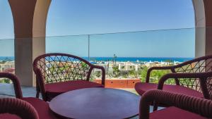 a patio with a table and chairs and a window at The Red - a GiGi Residence in Mājid Abū Zayd