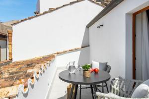 a patio with a table and chairs on a balcony at Palazzo Botta Suites in Cefalù
