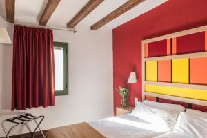 バルセロナにあるアパルタメンツ シウタット ヴェリャの赤い壁のベッドルーム1室(ベッド1台付)