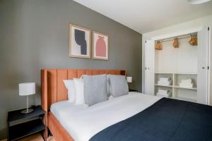 a bedroom with a large bed with white sheets at Olive Suite in Zürich
