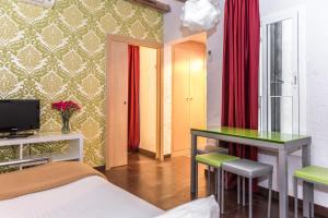 a bedroom with a bed and a desk and red curtains at Apartaments Ciutat Vella in Barcelona