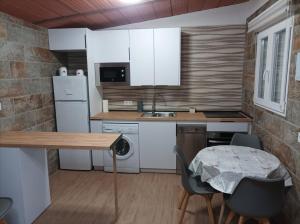 a kitchen with white appliances and a table and chairs at Casa Patria in Vejer de la Frontera