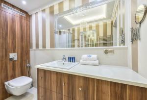 a bathroom with a sink and a toilet and a mirror at Dom Pod Wieżą By NorthSide Apartments in Sopot +20 photos