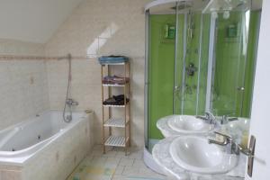 a bathroom with two sinks and a shower and a tub at Chambres Les Salles in Beauvoir