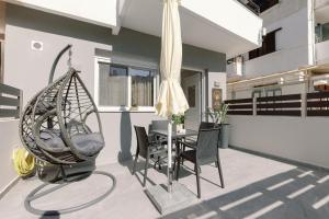 a patio with a swing and a table and chairs at City Pearl in Kos Town