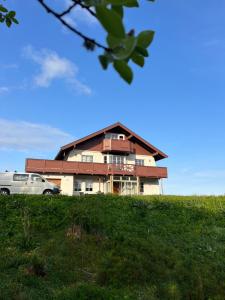 a house on top of a hill with a car in front at Huset ved fergekaien på Moskenes in Moskenes