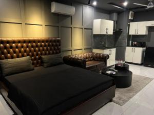 a bedroom with a bed and a couch and a table at Luxor Apartments & Suites - Opal in Lahore